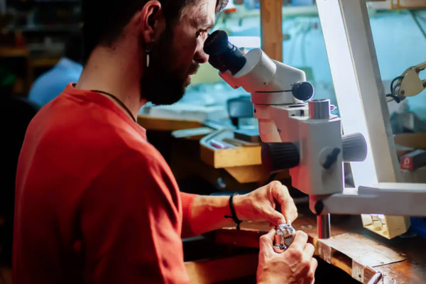Engraver sculpts jewelry with the help of a stereo microscope