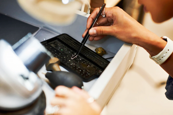 skilled artisan carefully examines sparkling jewels precision tools bright workspace